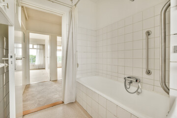 a bathroom with a bathtub and shower in the corner, taken from the inside looking into the room through the door