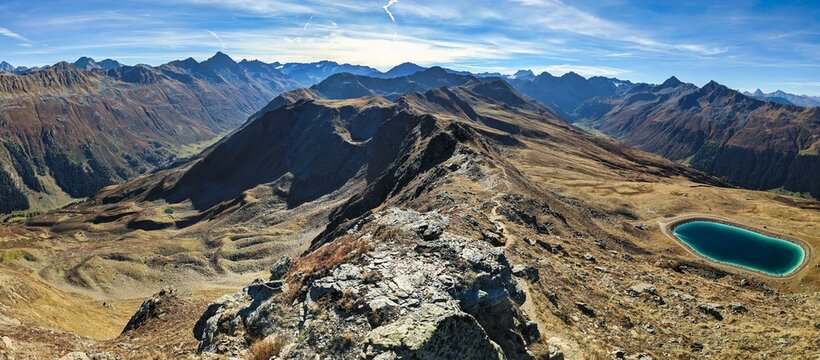 Hiking on the mountain ridge from Jakobshorn towards Tällihorn in the Davos Klosters Mountains. Breathtaking view of the Sertig and Dischma valley. High quality photo