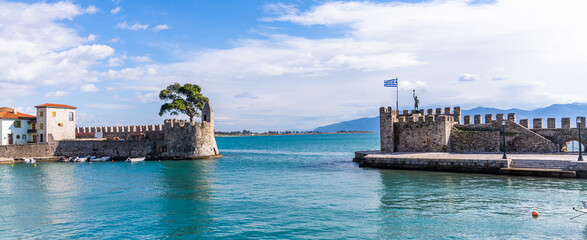 Nafpaktos, Greece - 4 february 2023 - The old city at the waterfront of the old venetian town with in the background the statue of Miguel de Cervantes Monument