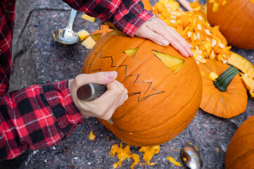 For Halloween, a face is cut into an orange pumpkin with a knife