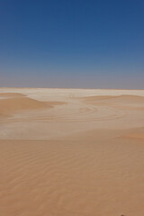 Fototapeta na wymiar Panorama of a limestone expanse in the Rub Al Khali desert with tyre tracks. Oman.