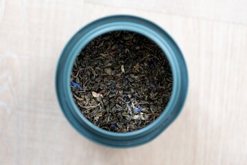 A portrait of dried loose fresh marrakech mint tea in a blue can. Ready to be used to make a delicious fresh cup of the warm beverage for some soothing zen and relaxation time.