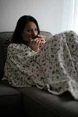 Pensative woman having coffee on a cold day, early in the morning.