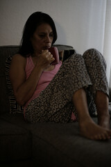 Adult woman sipping coffee early morning looking at phone.