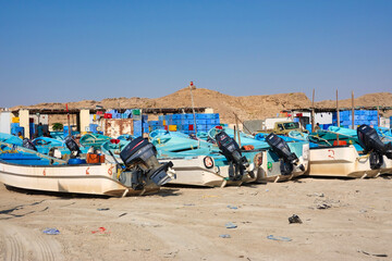 Fishing boats on the beach in the warehouse background.