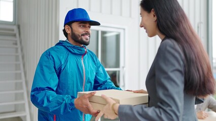 Woman manager taking pizza box from food delivery man for enjoy lunch together with colleagues in meeting room at office.Women manager orders food online to team. Delivery food concept