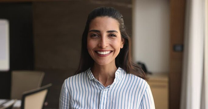Head shot portrait happy successful Brazilian businesswoman. Company executive, boss or CEO posing in modern boardroom smile staring at camera feel satisfied with career and professional achievements