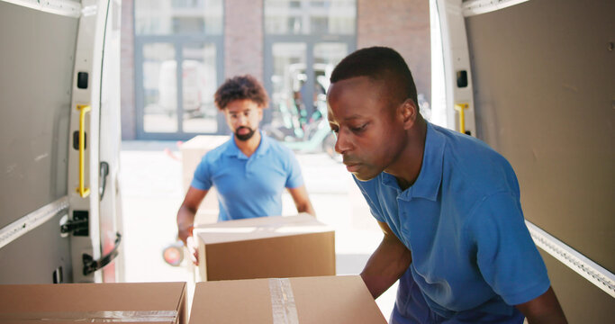 Young Delivery Men Loading Cardboard Boxes