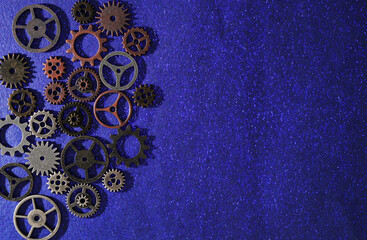 Variety of mechanical metal gears on blue background with copy space