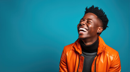 Fototapeta premium Young man laughs against a blue background.