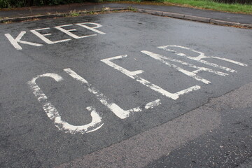 Road marking "Keep Clear" painted white taken on a residential road