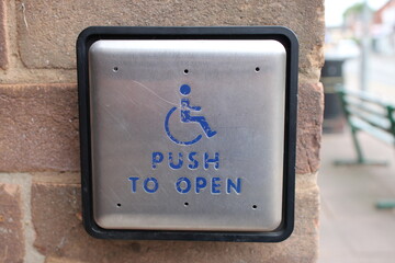 Disabled square door access button "Push to open" up close perspective