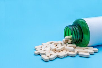 Medical pills and tablets spilling out of a drug bottle. Front view with copy space