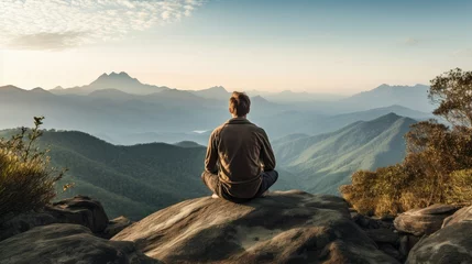 Poster A person sits on a rocky cliff, gazing at a distant mountain range. The serene landscape inspires contemplation and reflection. A peaceful and majestic view that evokes tranquility and wanderlust. © Aidas