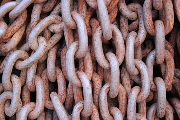 Close up picture of multiple large heavy rusted iron chains