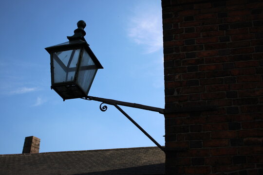 Vintage metal street lantern attached to corner of building 