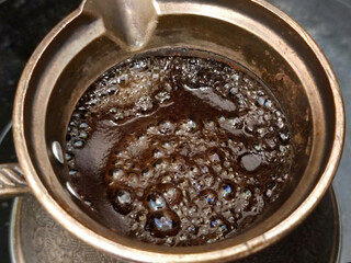 boiling coffee in a cezve close-up