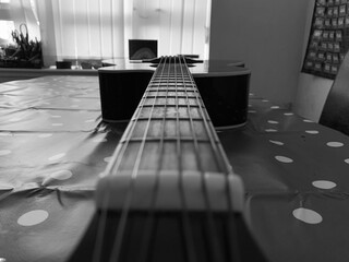 A 6 String acoustic guitar close up focus on fret board