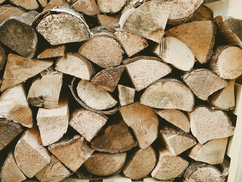 A close up picture taken from an outdoor log store full of seasoned cut wood ready to burn