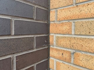 Two different coloured brick walls black brick and a sand coloured brick angled shot