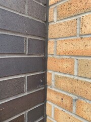Two different coloured brick walls black brick and a sand coloured brick angled shot