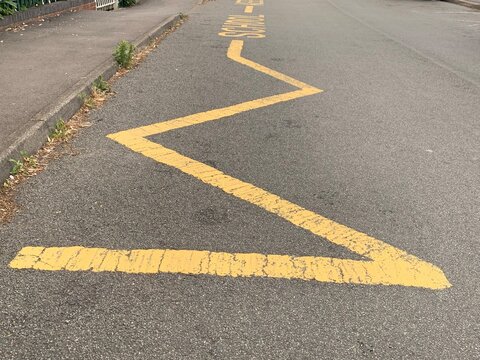 Yellow Zig Zag Lines Indicating To Motorists To Keep Clear No Parking Taken Outside School Entrance UK