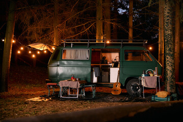Camper trailer in woods at night.