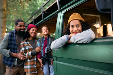 Happy black kid in camper trailer during family trip in nature looking at camera.