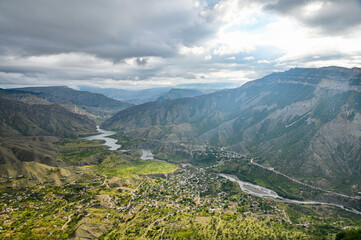 Fototapeta na wymiar Beautiful landscape with mountains, valley and a river on a sunny summer day with clouds. Dagestan