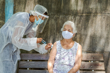 Mulher idosa recebe vacina contra covid em área rural de Guatani, estado de Minas Gerais, Brasil. - obrazy, fototapety, plakaty