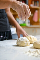 baker kneading dough on table