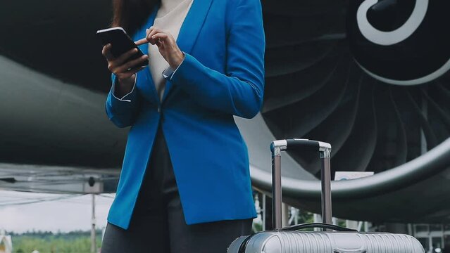 businesswoman hand holding tablet while carrying luggage with airport background.