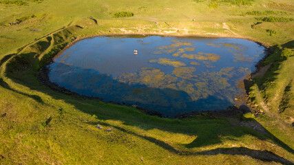 Lake and pond on the plateau. A lake in a green mountain landscape. Lake view taken with a drone....