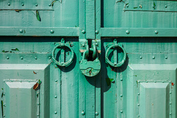 Rusty padlock on an old closed door.