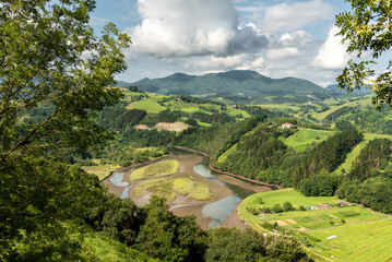 Landscape of the mountains covered by green vegetation and Urola river on the surrounding of Zumaia...