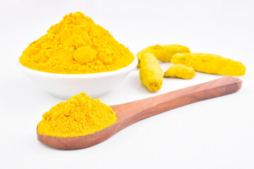 Turmeric powder in bowl and spoon isolated on white background