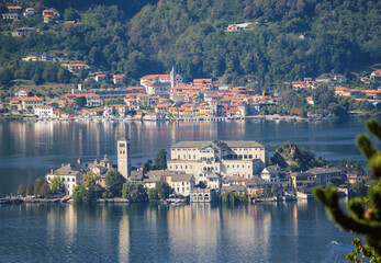 Fototapeta premium Aerial view of Lake Orta, the island of San Giulio and in the background the sunny houses of Pella renowned tourist village in Piedmont.