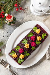 Festive layered shuba salad. Traditional Russian Christmas New Year vegetable salad roll with herring and boiled vegetables. View from above.