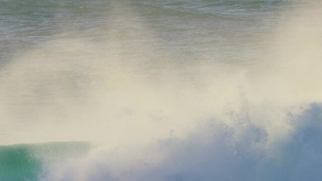 huge stormy wave breaking in the ocean at sunset