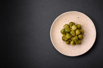 Delicious boiled Brussels sprouts on a ceramic plate on a dark concrete background