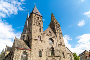 Fototapeta na wymiar Low angle view of the 12th century towers and 13th century spire of the Gothic Saint James Church, or Sint-Jacobskerk, in Ghent, Belgium. 