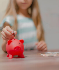 Obraz na płótnie Canvas Hand putting coin to piggy bank, saving money concept