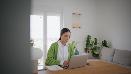 Businesswoman working kitchen table with laptop close up. Girl typing keyboard