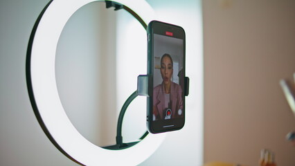 Makeup artist talking cellphone screen home closeup. Blogger recommend cosmetics