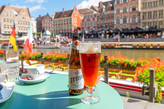 General table view of a bottle and pint glass of Gruut Belgian Amber Ale beer brewed by Gentse Gruut Brouwerij, at a sidewalk cafe in the medieval old town of Ghent, Belgium on September 4 2023.	