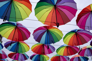Fototapeta na wymiar A lot of rainbow-colored umbrellas against the sky.