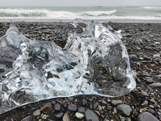 Iceberg fragment on Diamond Beach, Iceland on windy overcast autumn afternoon.