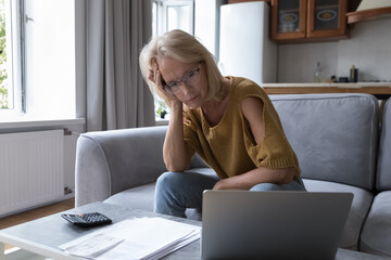 Concerned mature worried homeowner woman checking bills for payment, finding lack of money, overspending, blocked bank accounts, bankruptcy, too high prize, financial mistake, problems, loss - obrazy, fototapety, plakaty