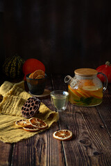 Fruit tea with oranges and mint  in glass kettle on wooden table 