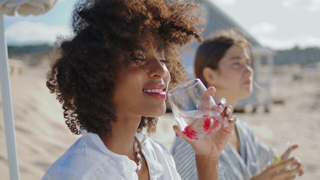 Beautiful woman enjoying cocktail closeup. Happy african american drinking soda